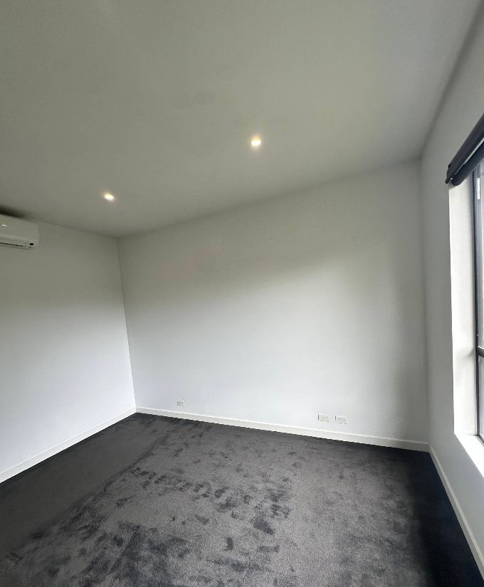 Bedroom finished in warm white with charcoal carpet